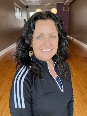 Smiling woman in black athletic jacket.